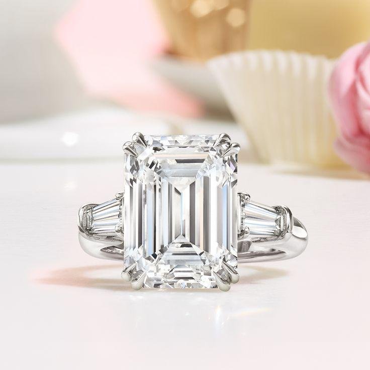 Harry Winston emerald-cut diamond engagement ring displayed against a pale background.