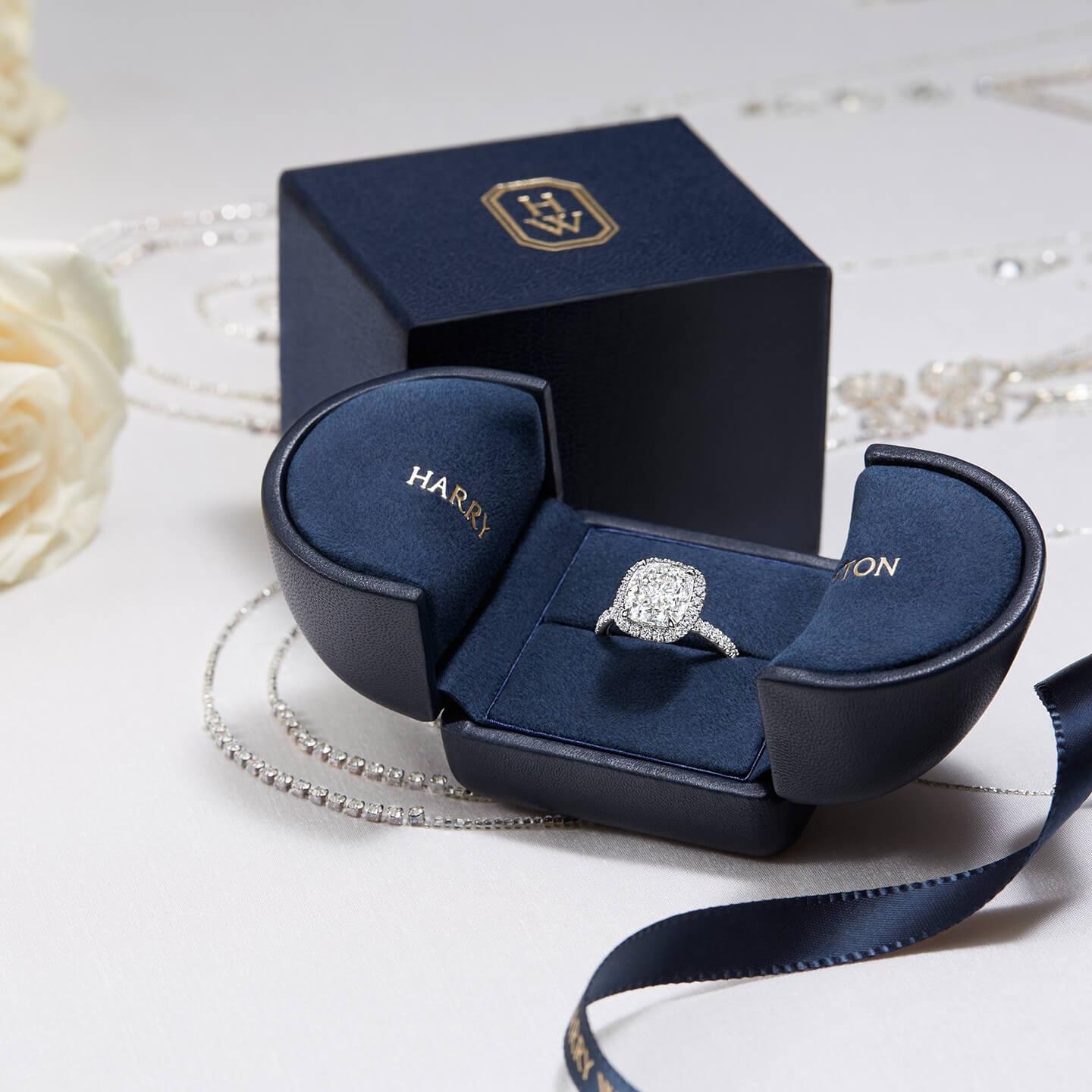 Harry Winston engagement rings presented with their original navy-blue boxes.
