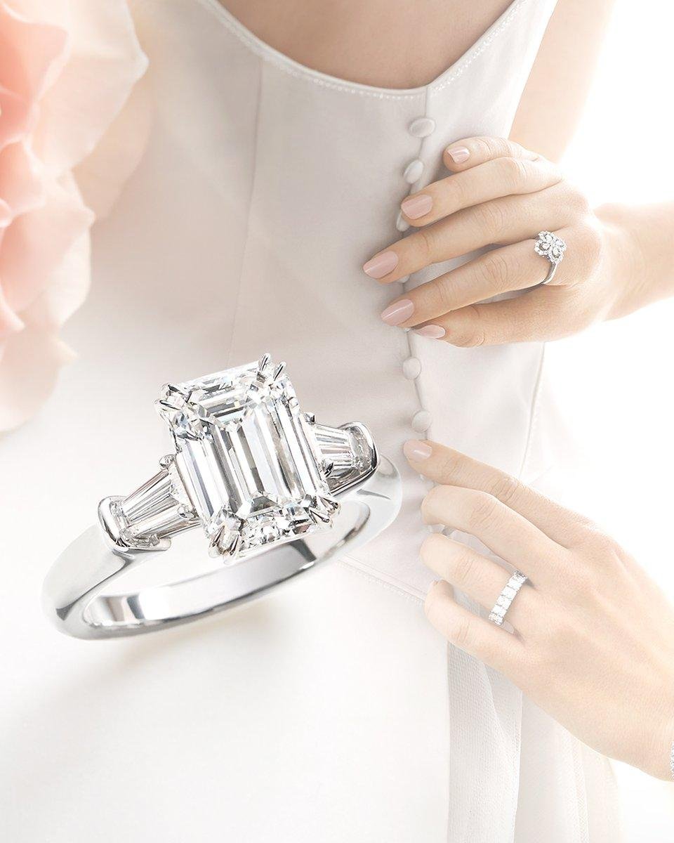 Harry Winston emerald-cut engagement ring worn on the hand.