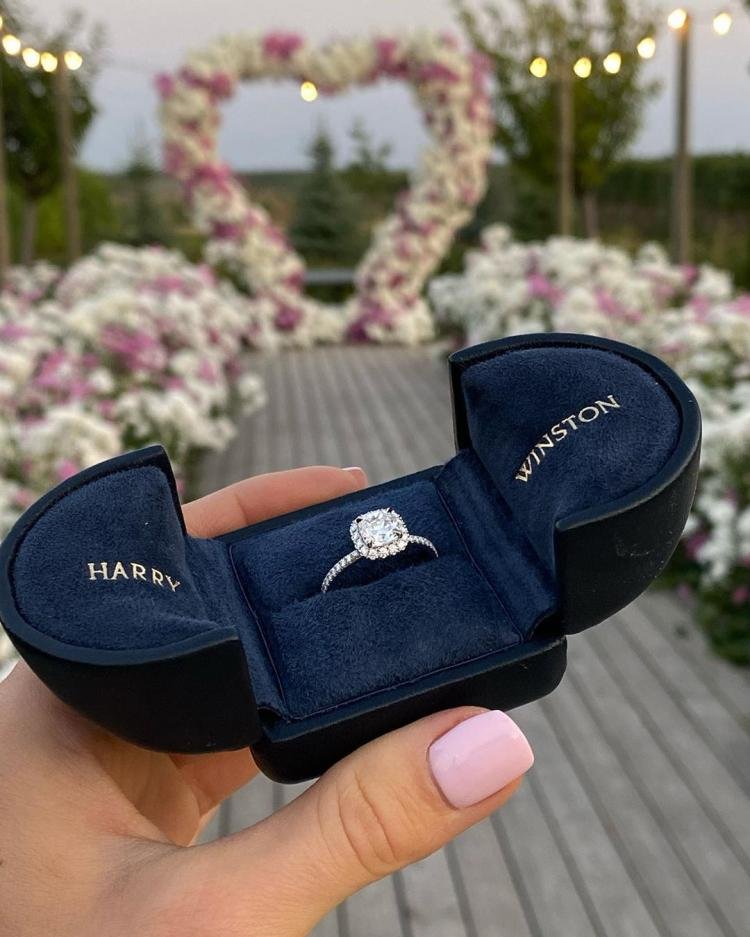 Harry Winston pear-shaped diamond engagement ring in a navy-blue presentation box.