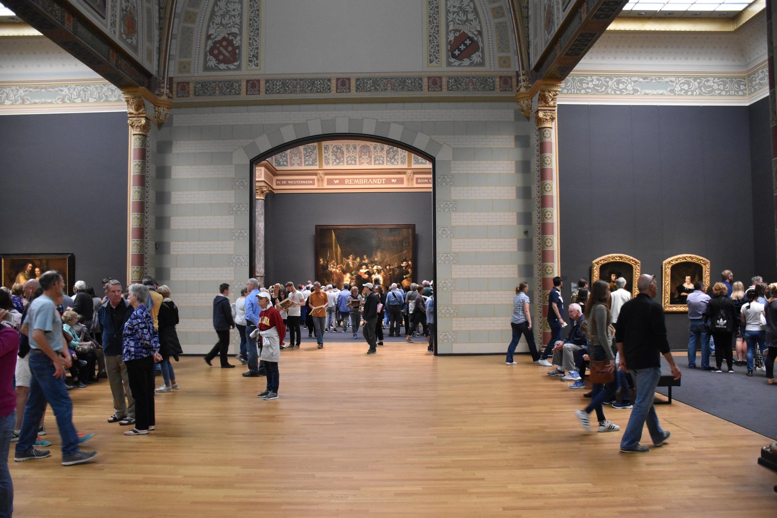 Visitors moving through the Rijksmuseum galleries.
