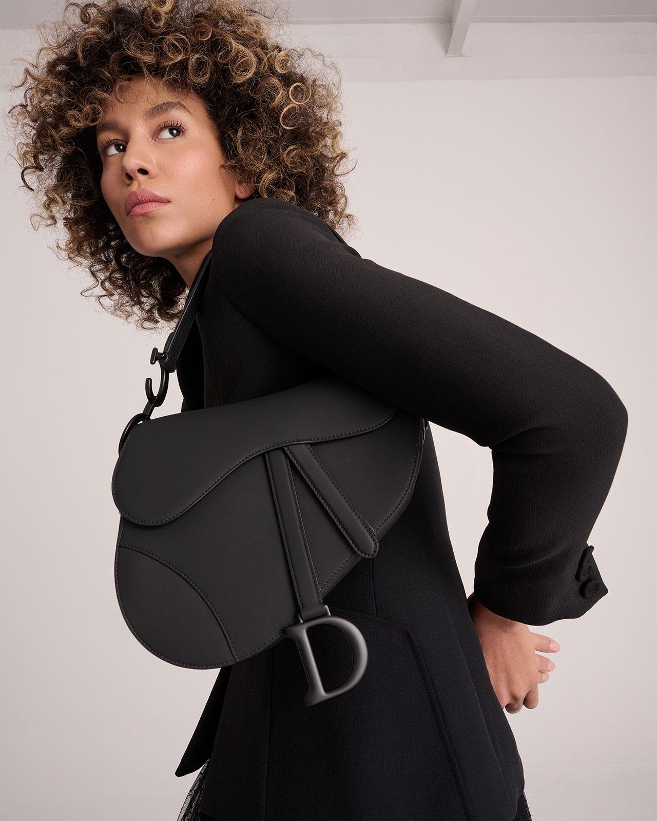 Black Dior Saddle Bag photographed in an elegant neutral interior.