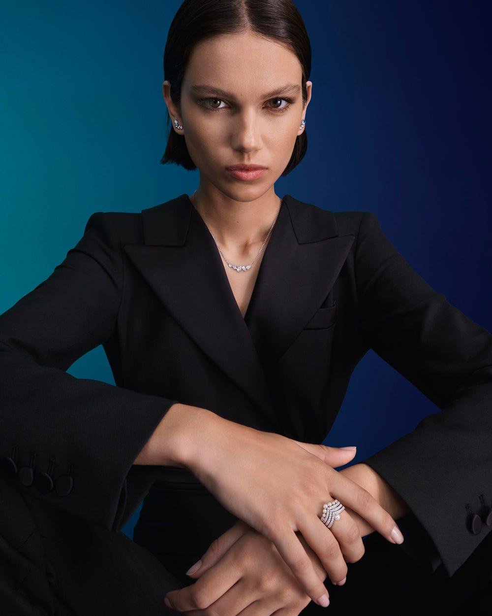 Model wearing several Chaumet rings with a tailored black outfit.