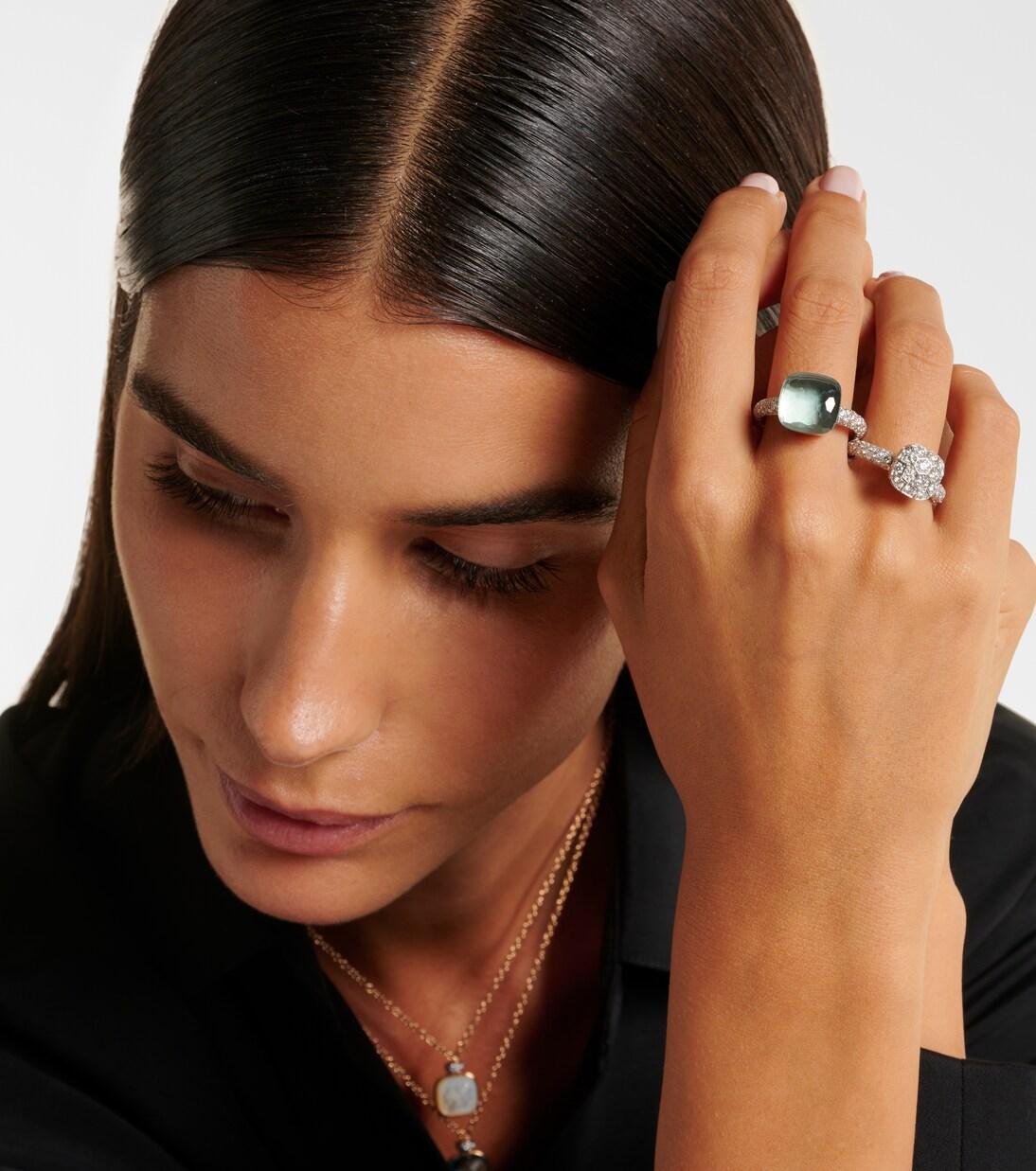Model styling blue and green Pomellato rings with a dark knit.