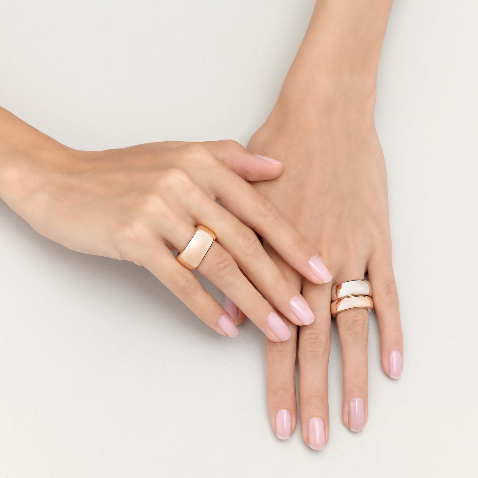 Hand wearing a selection of Pomellato gemstone and gold rings.