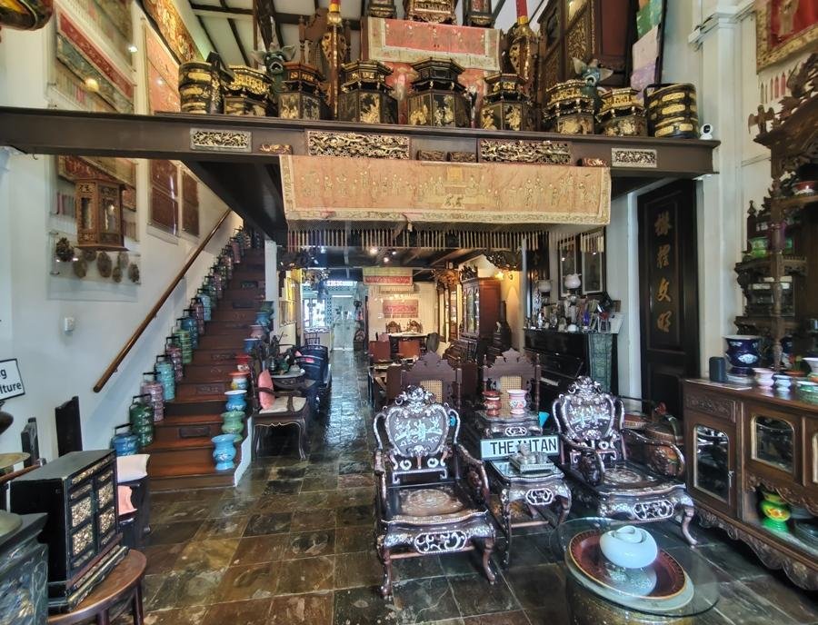 Visitor examining Peranakan objects inside The Intan.