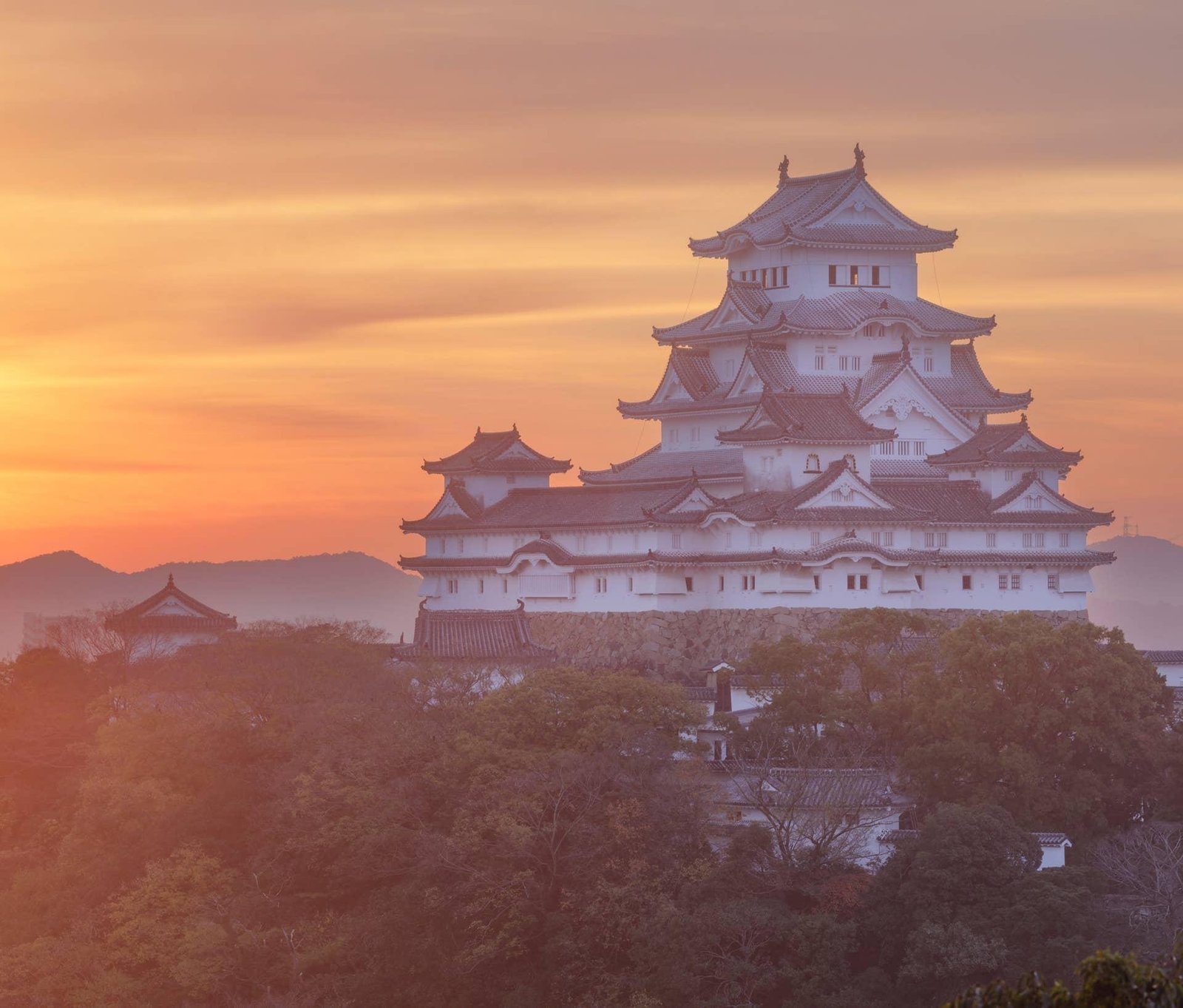 Himeji Castle illuminated by clear daylight above its defensive walls.