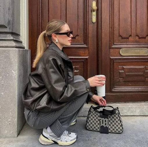 Model styling Off-White sneakers with a restrained contemporary outfit.
