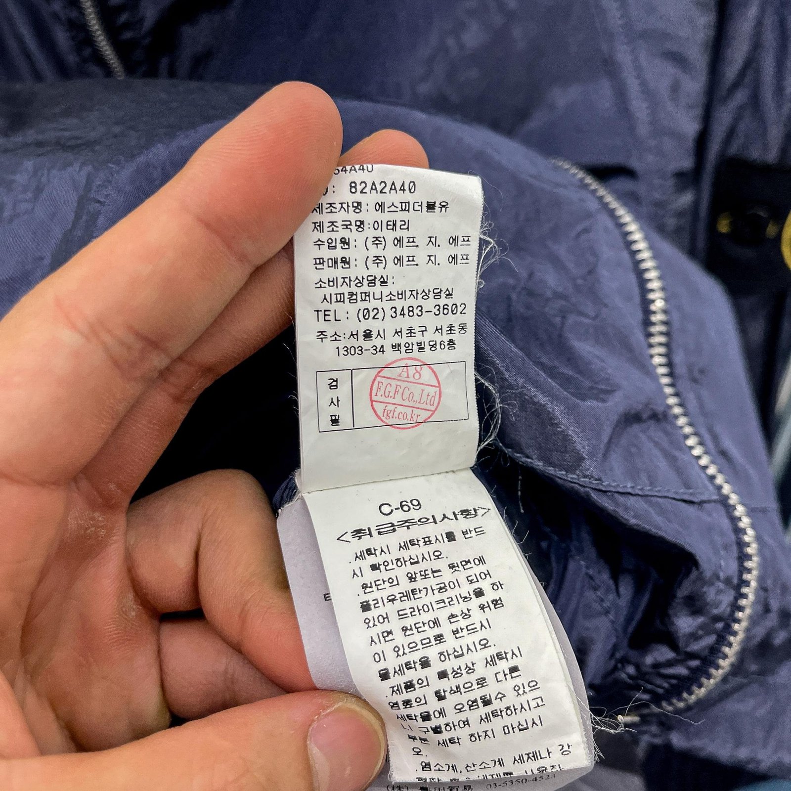 Care label, removable compass badge and fabric details on a Stone Island jacket.