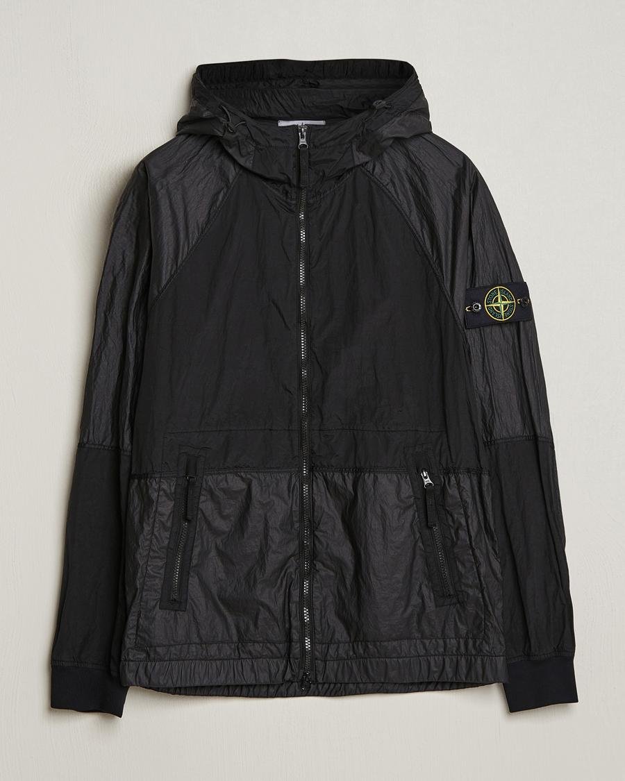 Stone Island technical outerwear presented in an urban setting.
