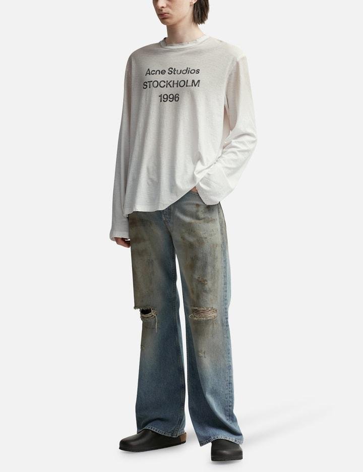 Distressed hem, logo print and care details on an Acne Studios shirt.