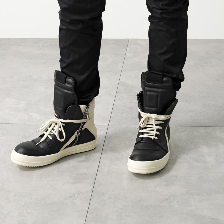 Black-and-milk Rick Owens Geobasket sneakers in a dark architectural setting.
