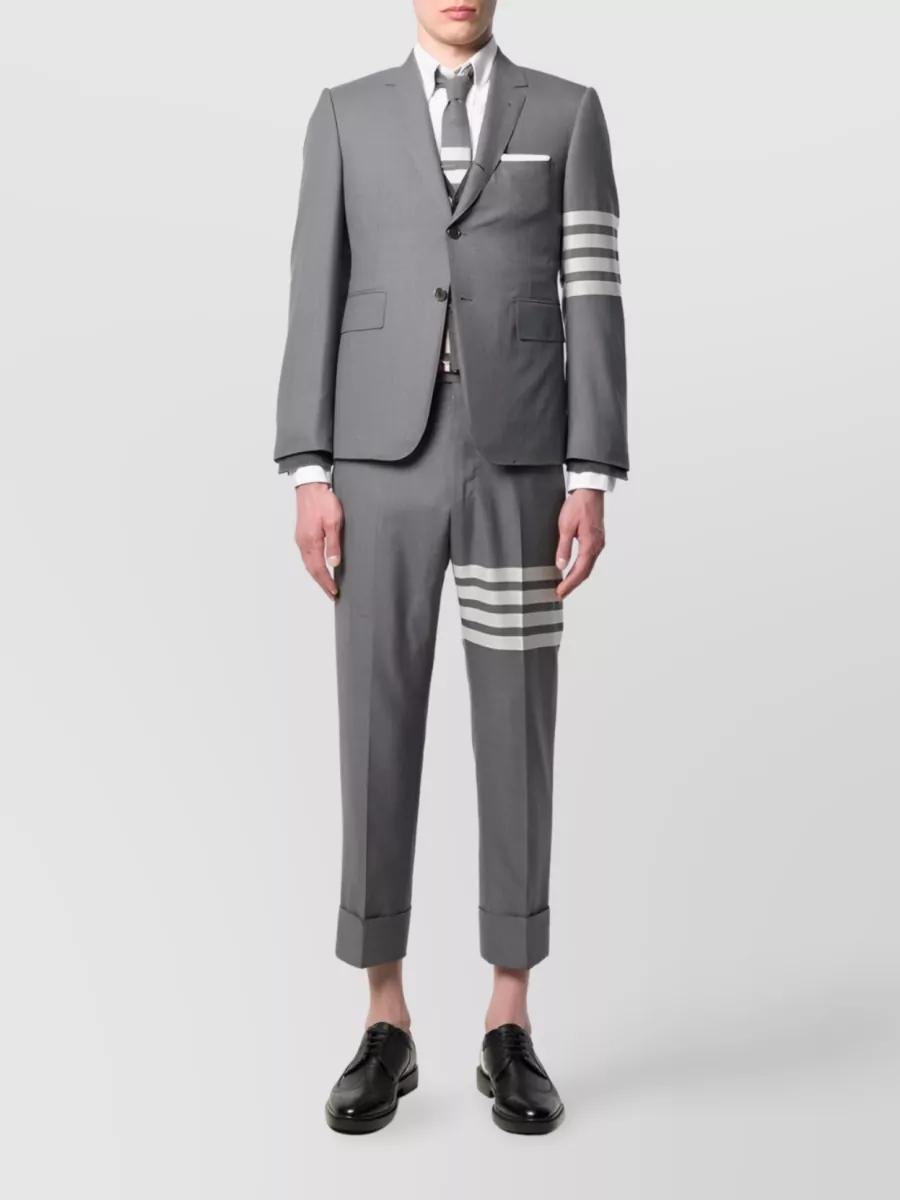 Model wearing a cropped grey Thom Browne suit with visible cuffs and ankles.