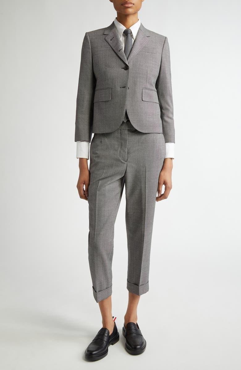 Model wearing a structured Thom Browne suit in motion.