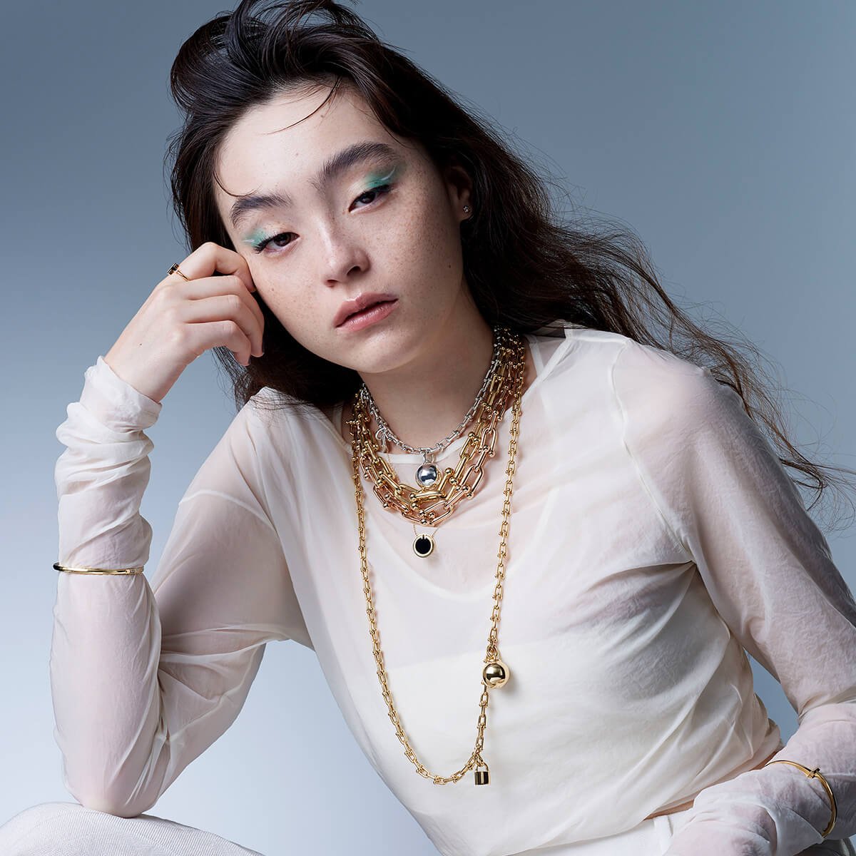 Model wearing layered Tiffany HardWear necklaces with different chain weights.