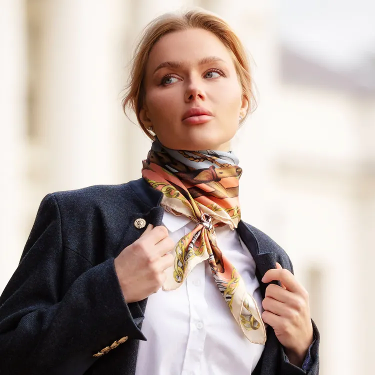 Model wearing a colourful Hermès silk scarf with a dark blazer and white shirt.