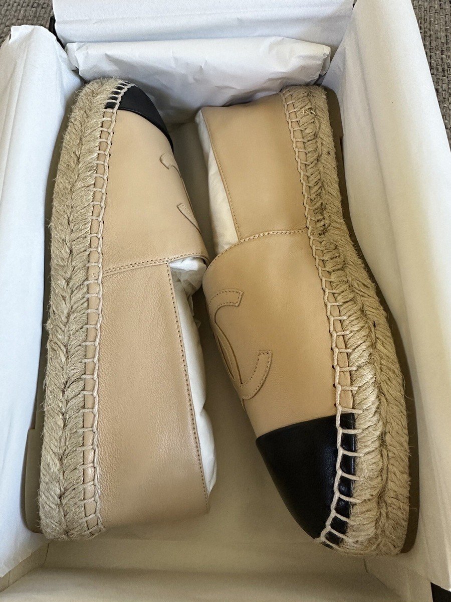 Beige and black Chanel lambskin espadrilles in a luxury product setting.