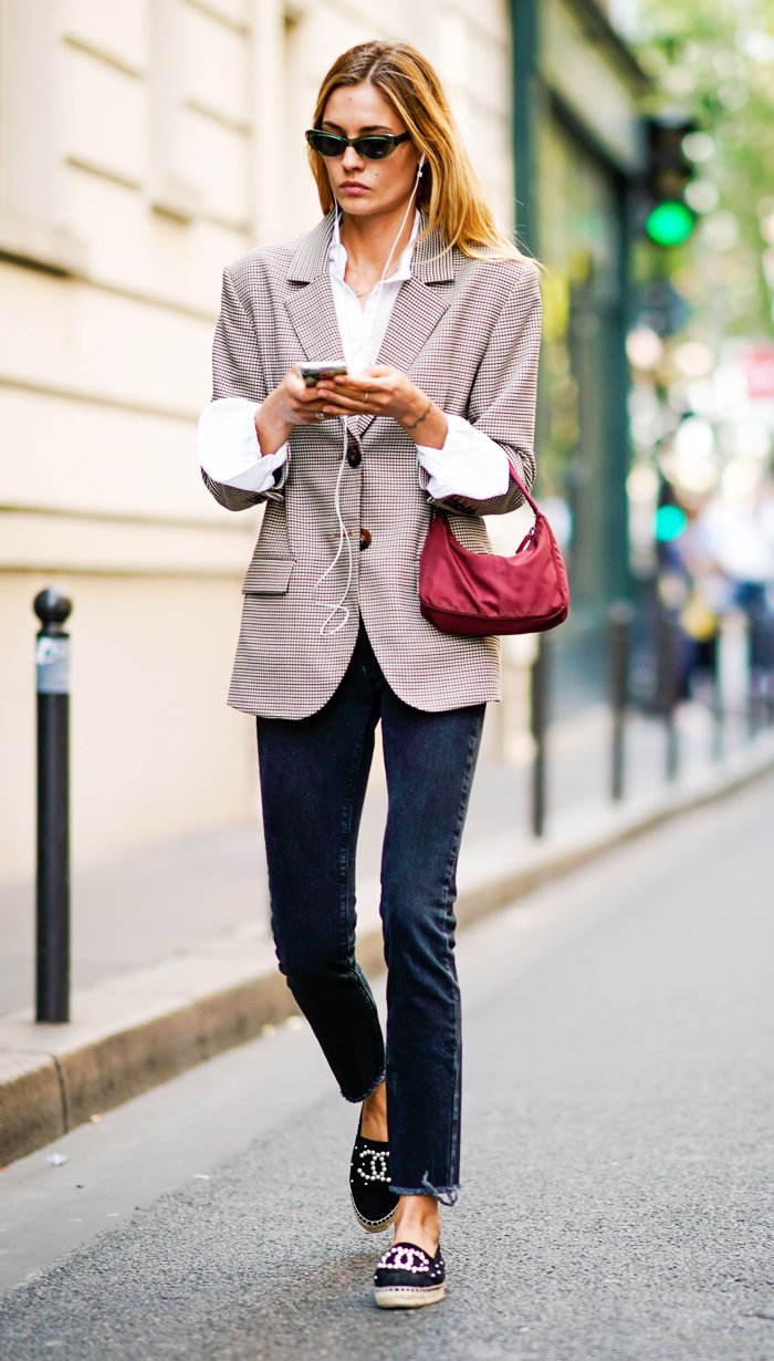 Model styling black Chanel espadrilles with a checked blazer and dark jeans.