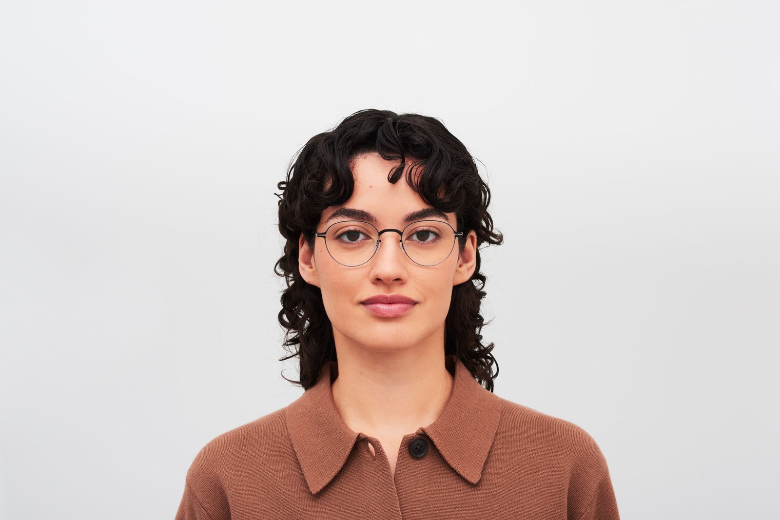 Model wearing MYKITA MEL optical frames with a brown collared shirt.
