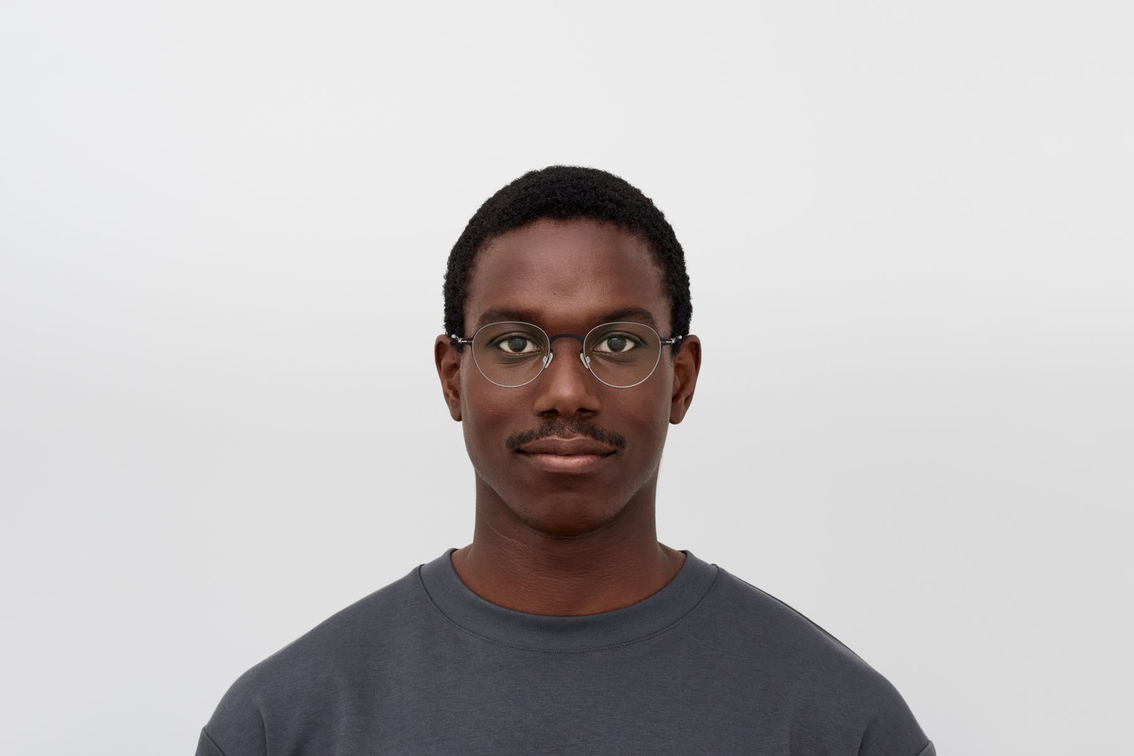 Model wearing MYKITA MEL optical glasses with a dark crew-neck top.