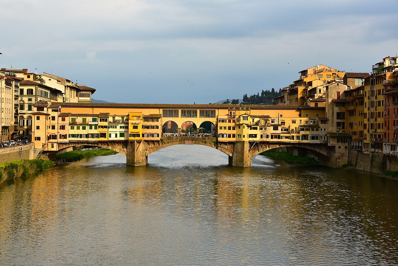 Warm late-day light on Ponte Vecchio and its river reflections.