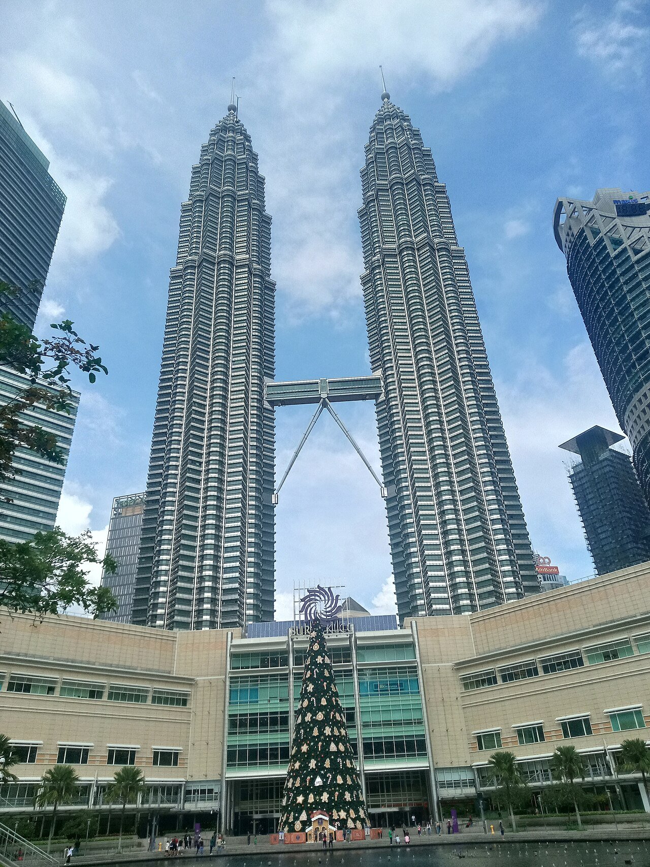 Petronas Twin Towers above Suria KLCC on a cloudy day.