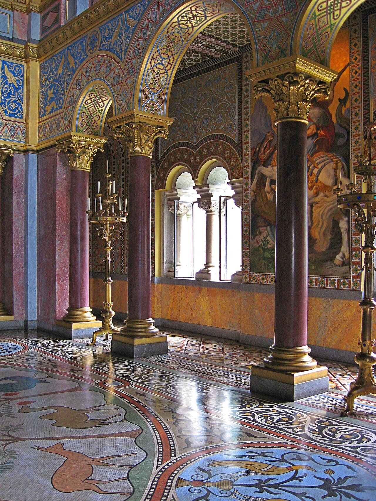 Ornate columns, painted arches and mosaic flooring inside Neuschwanstein Castle.