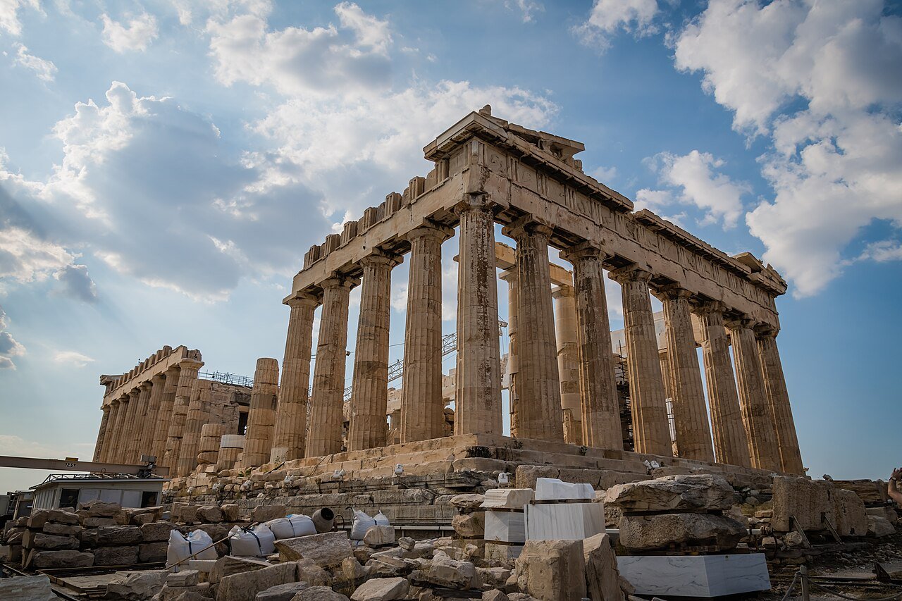 Parthenon columns rising above ancient marble remains.