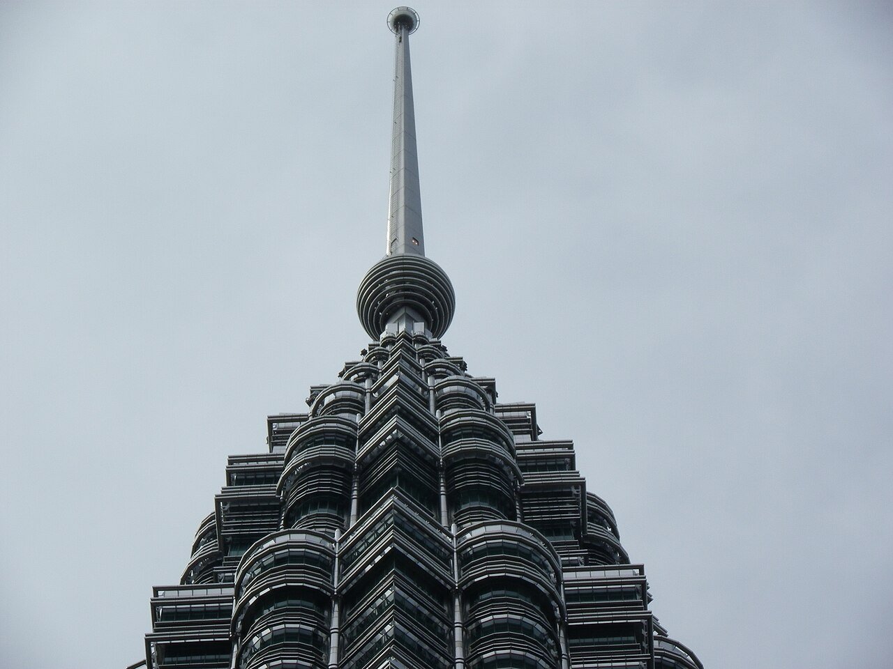Close-up of a Petronas tower spire and stepped upper structure.