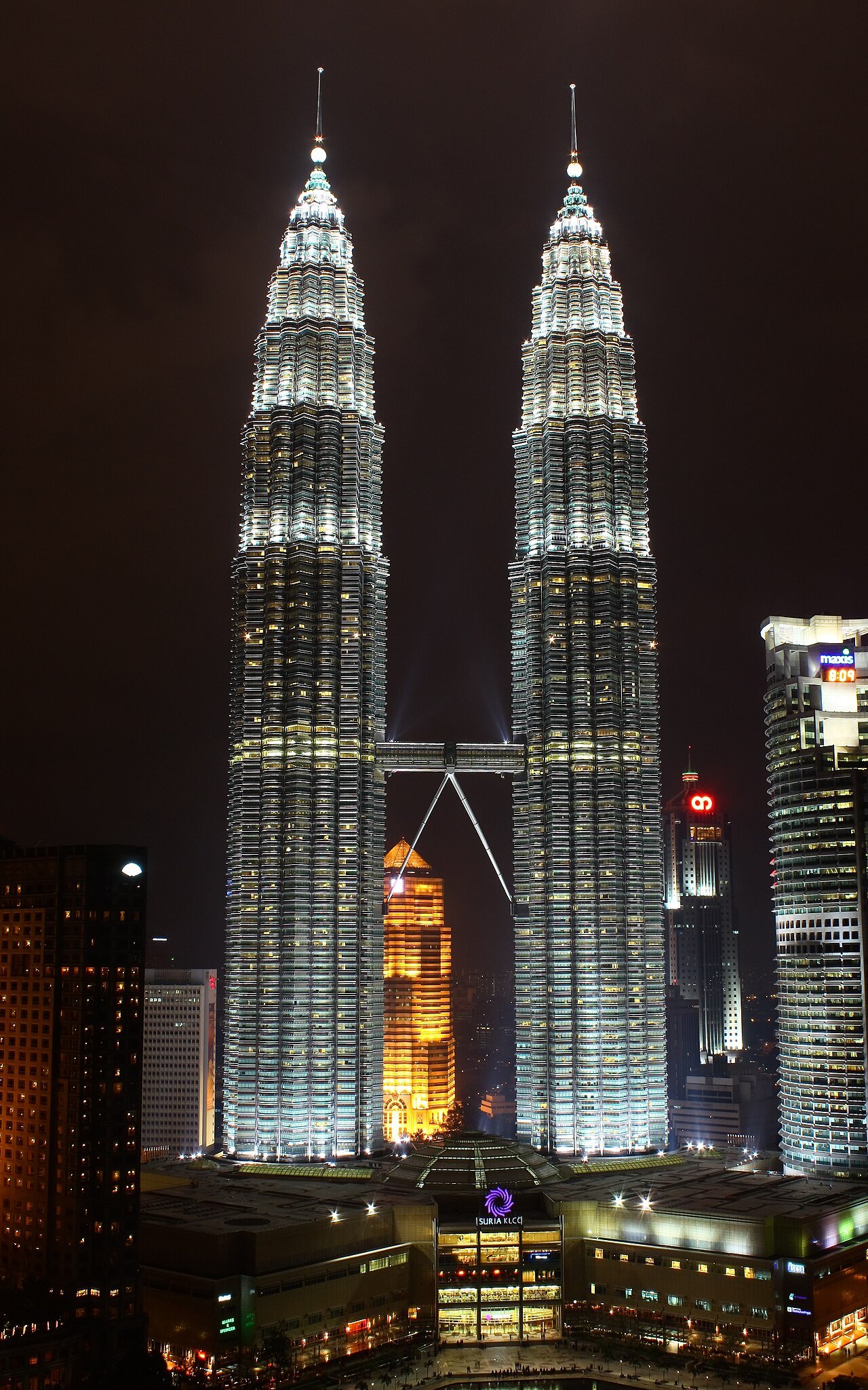 Both Petronas towers illuminated against the night sky.