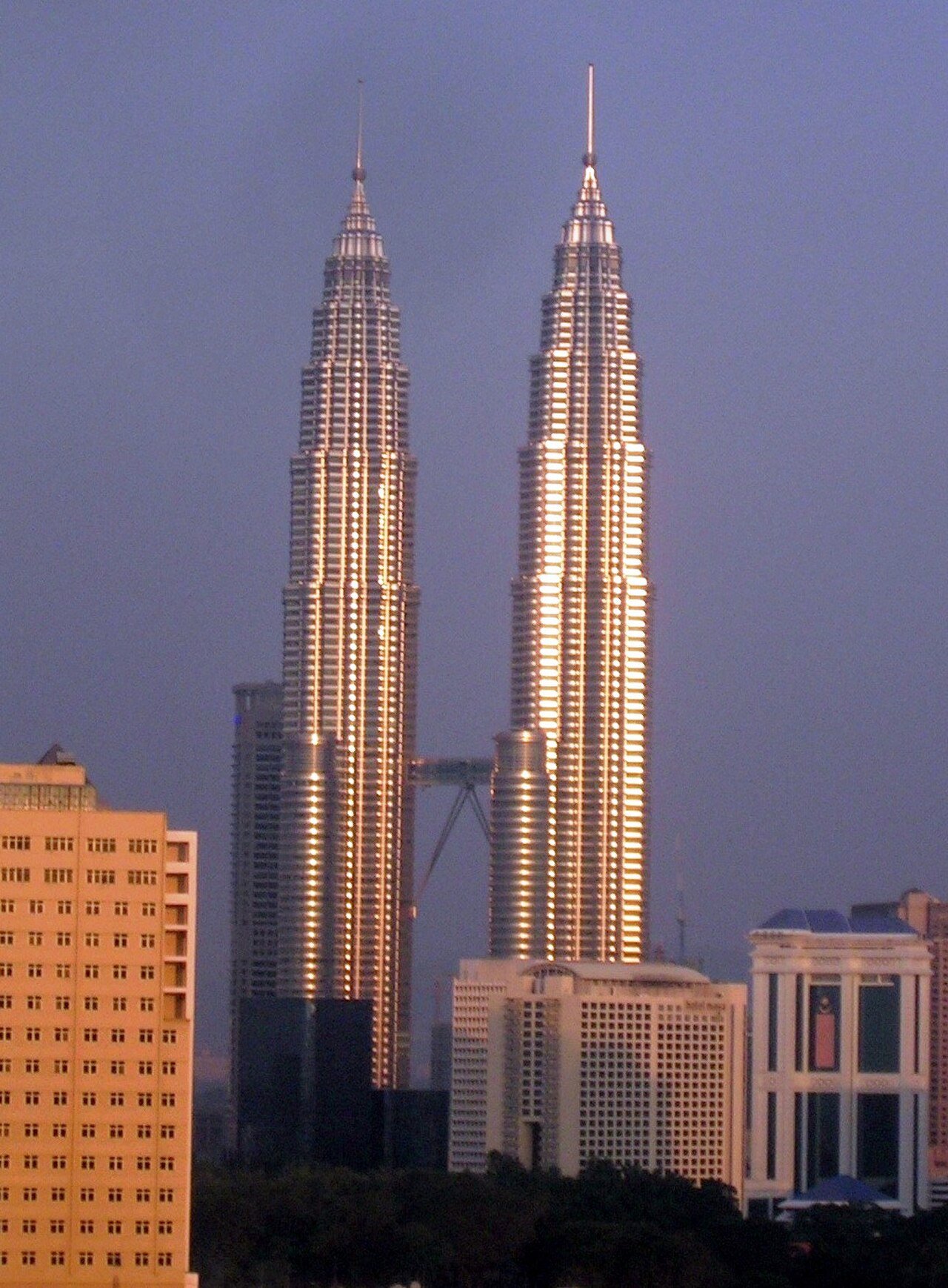 Petronas Twin Towers against a soft sunset sky.