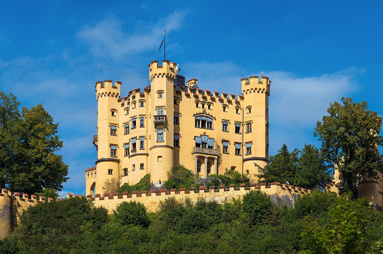 Yellow towers and facade of Hohenschwangau Castle.