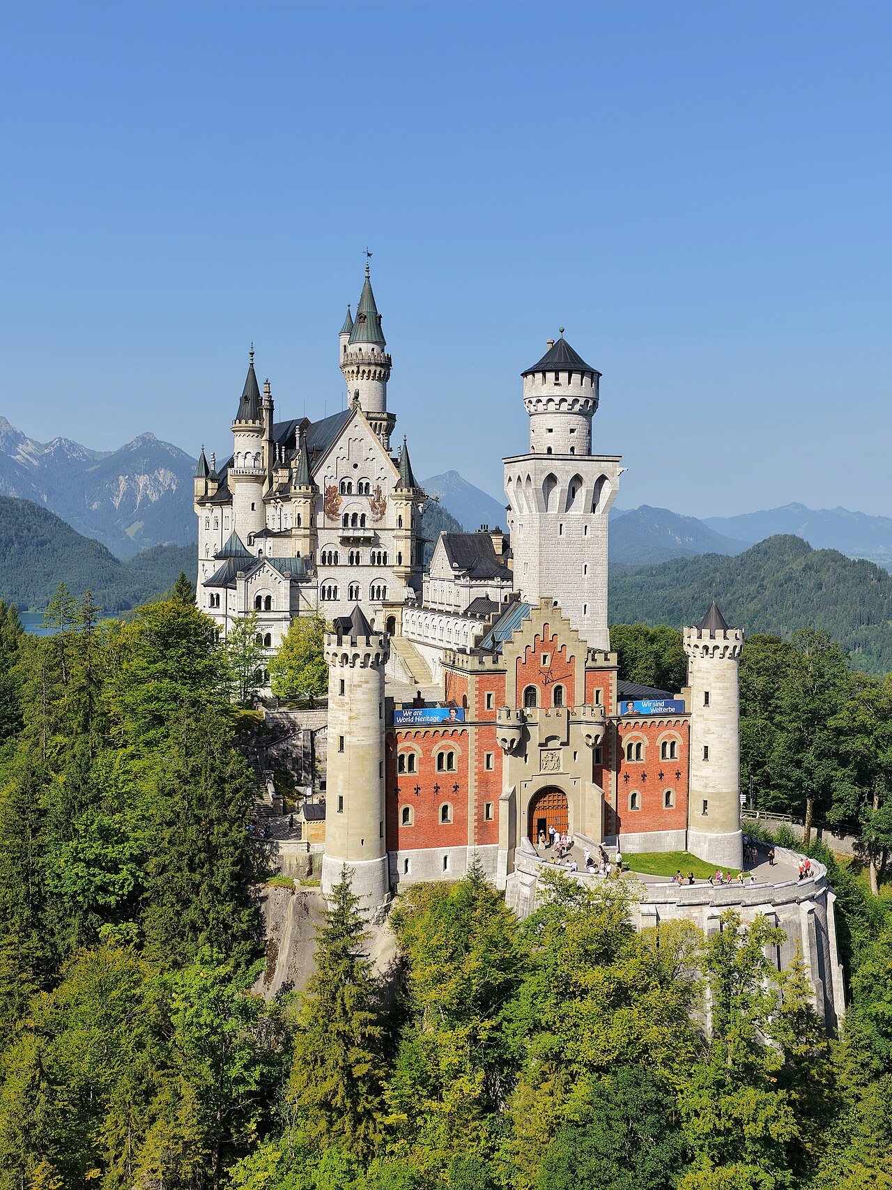 Neuschwanstein Castle’s towers and gatehouse above a forested ridge.