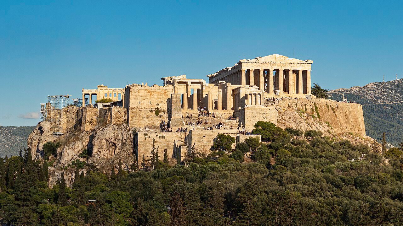 Parthenon and the Acropolis plateau above Athens in warm daylight.