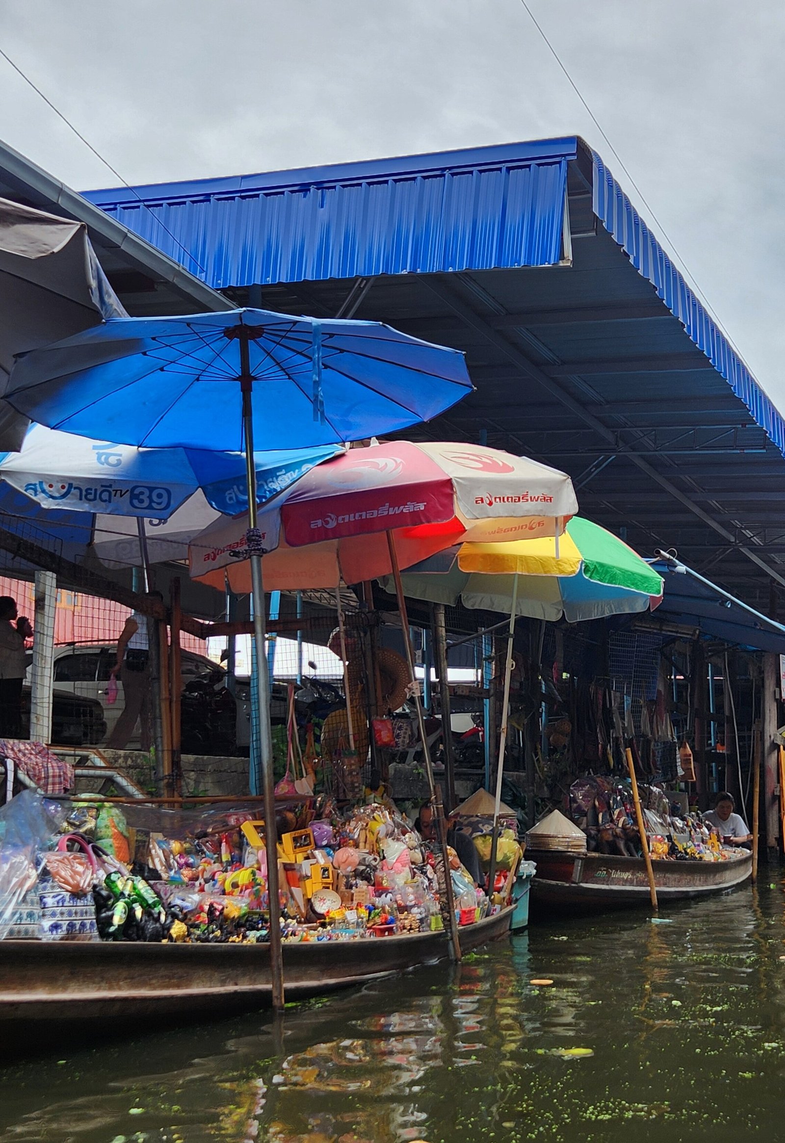 Colourful umbrellas above boats and stalls at Damnoen Saduak.