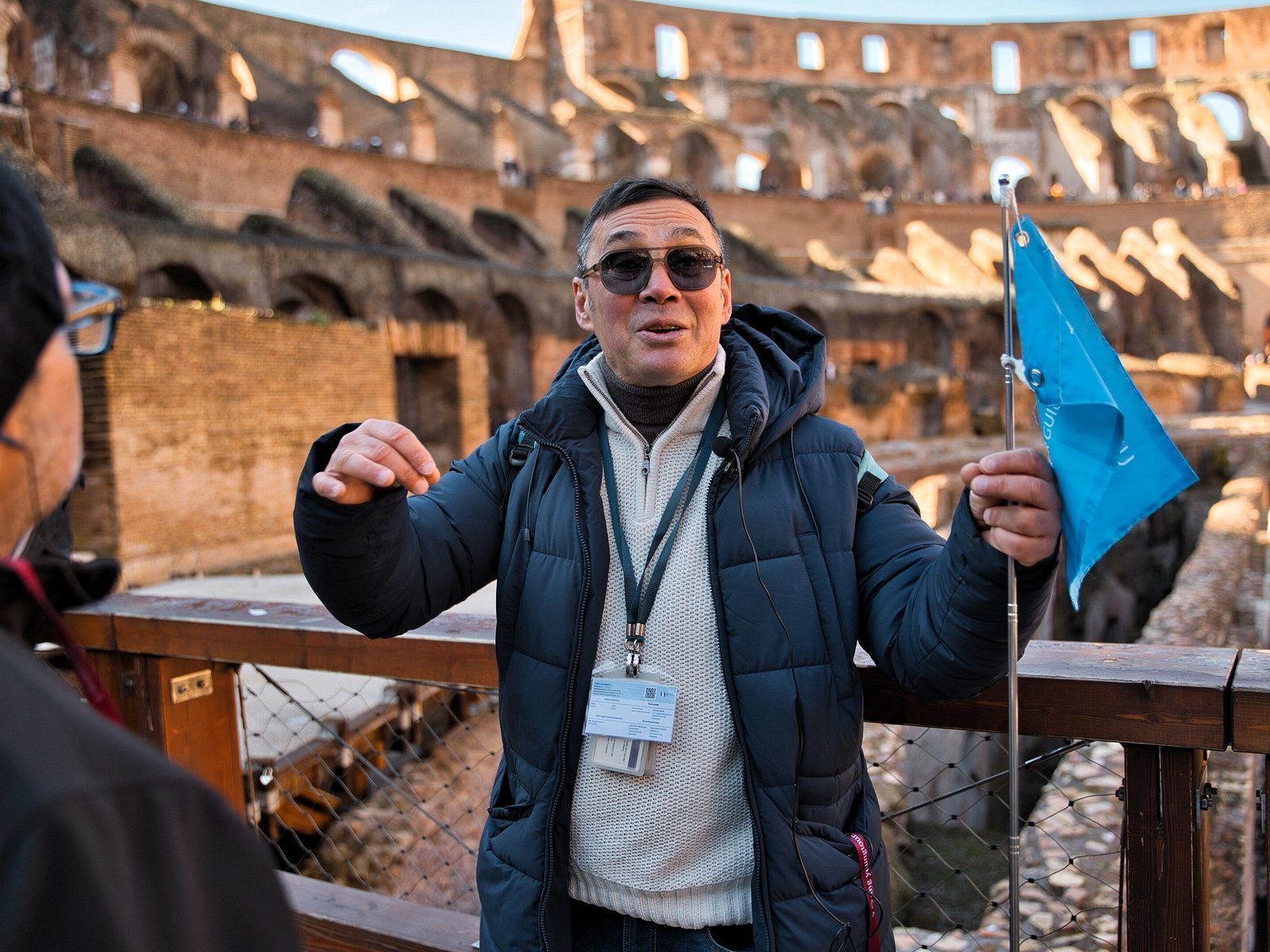 A guide explaining the Colosseum interior to visitors.