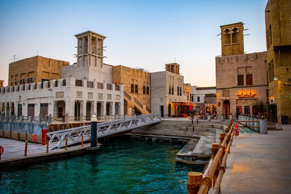 Al Seef waterfront buildings and traditional wind towers beside Dubai Creek