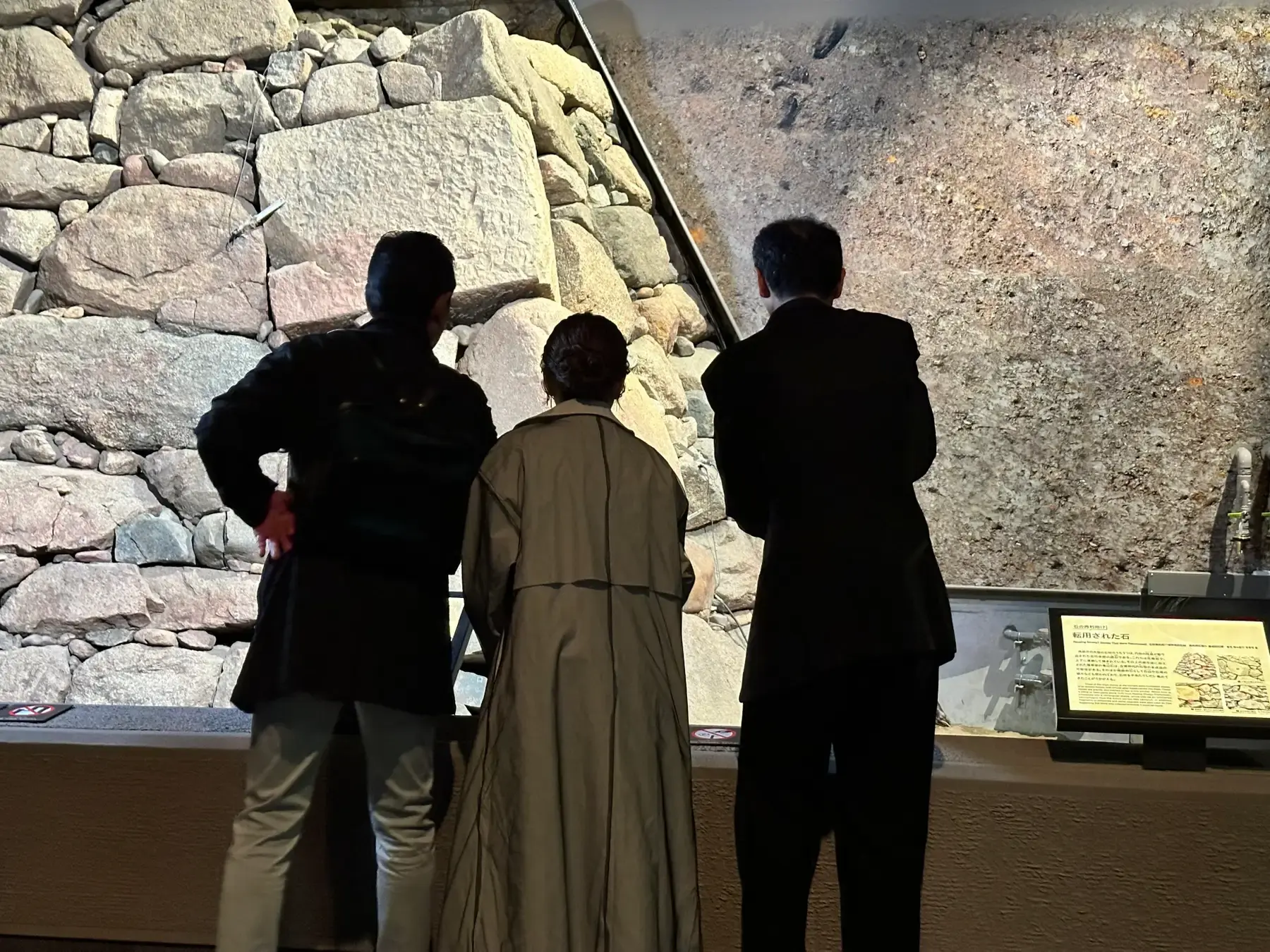 Visitors viewing excavated stonework in the Toyotomi Stone Wall Museum