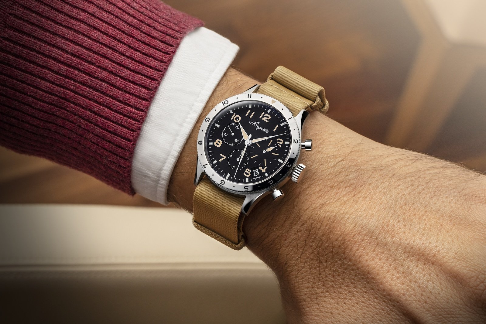 Model pairing a Breguet Type XX watch with burgundy knitwear and a white shirt.