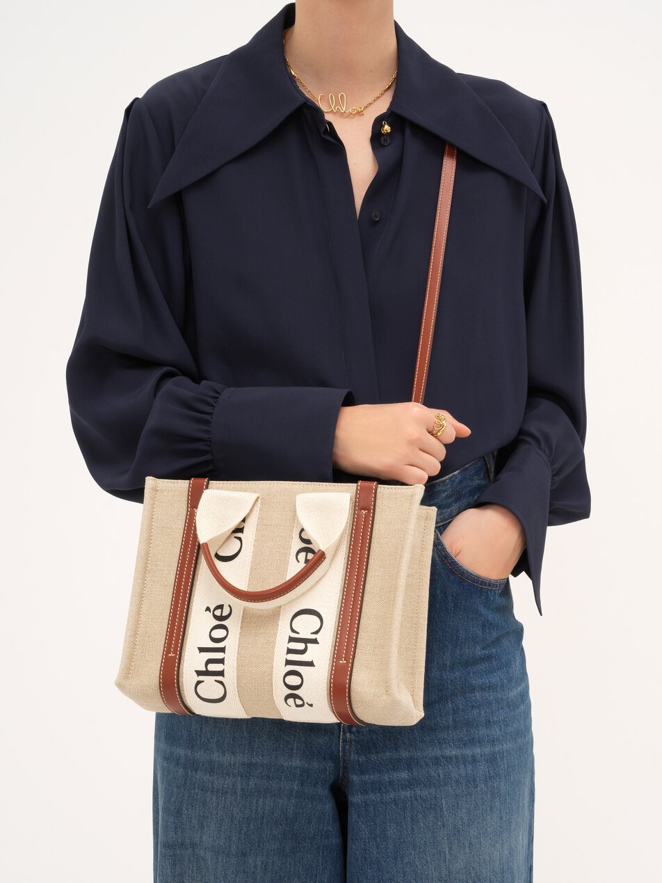 Model carrying the small linen Chloé Woody tote crossbody