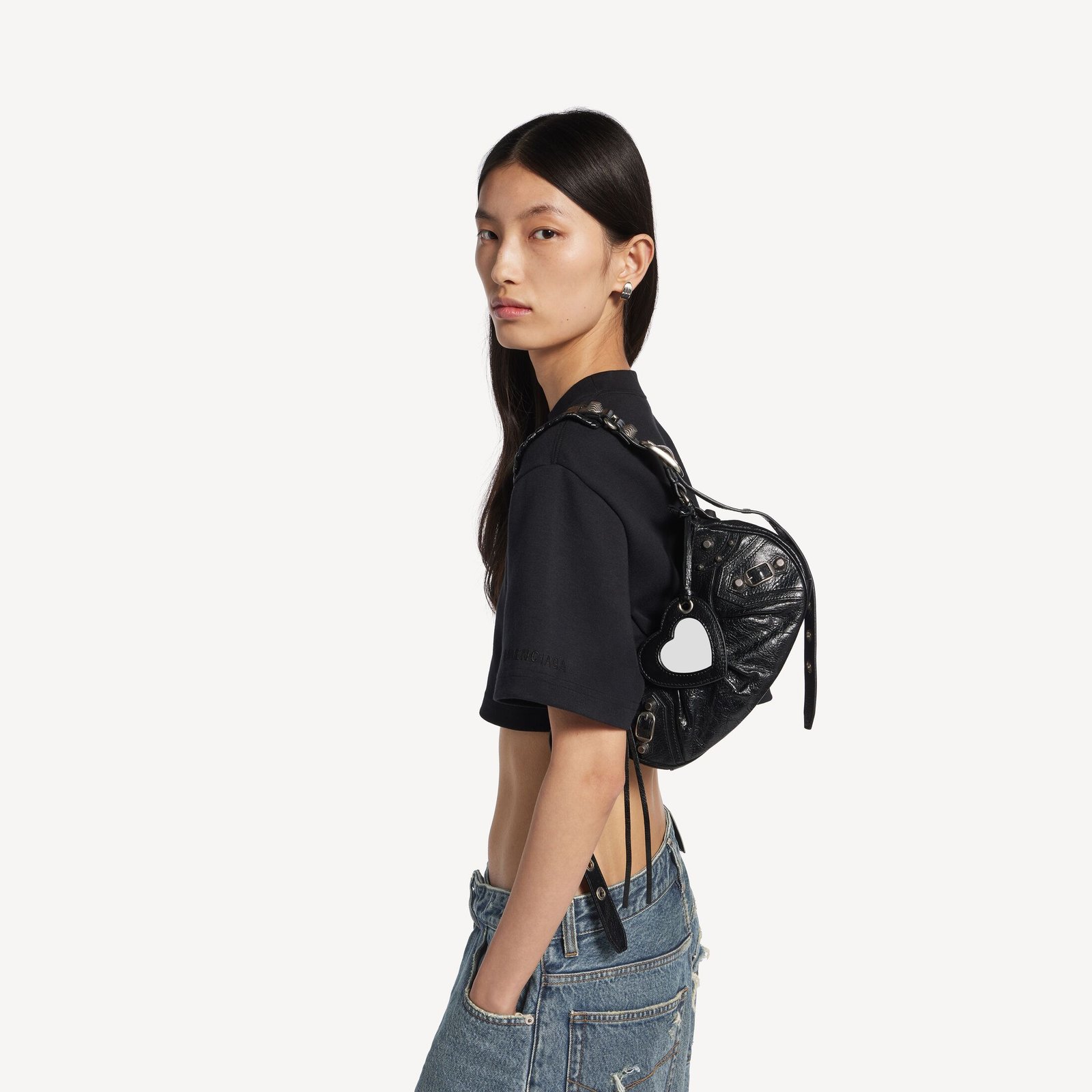 Model wearing a black Balenciaga Le Cagole XS on the shoulder.