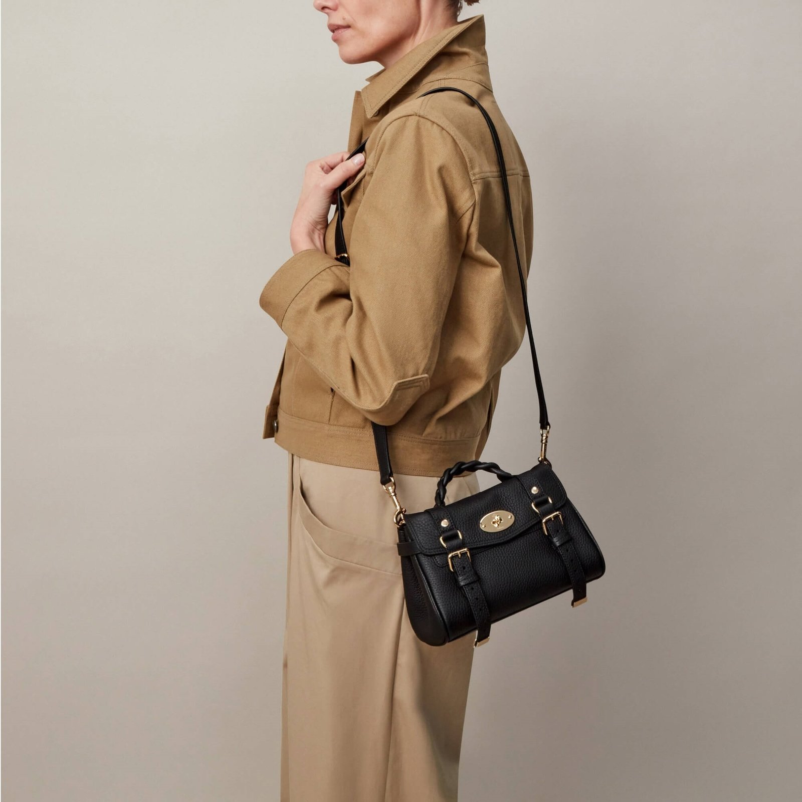 Model wearing a black Mini Alexa with a neutral jacket