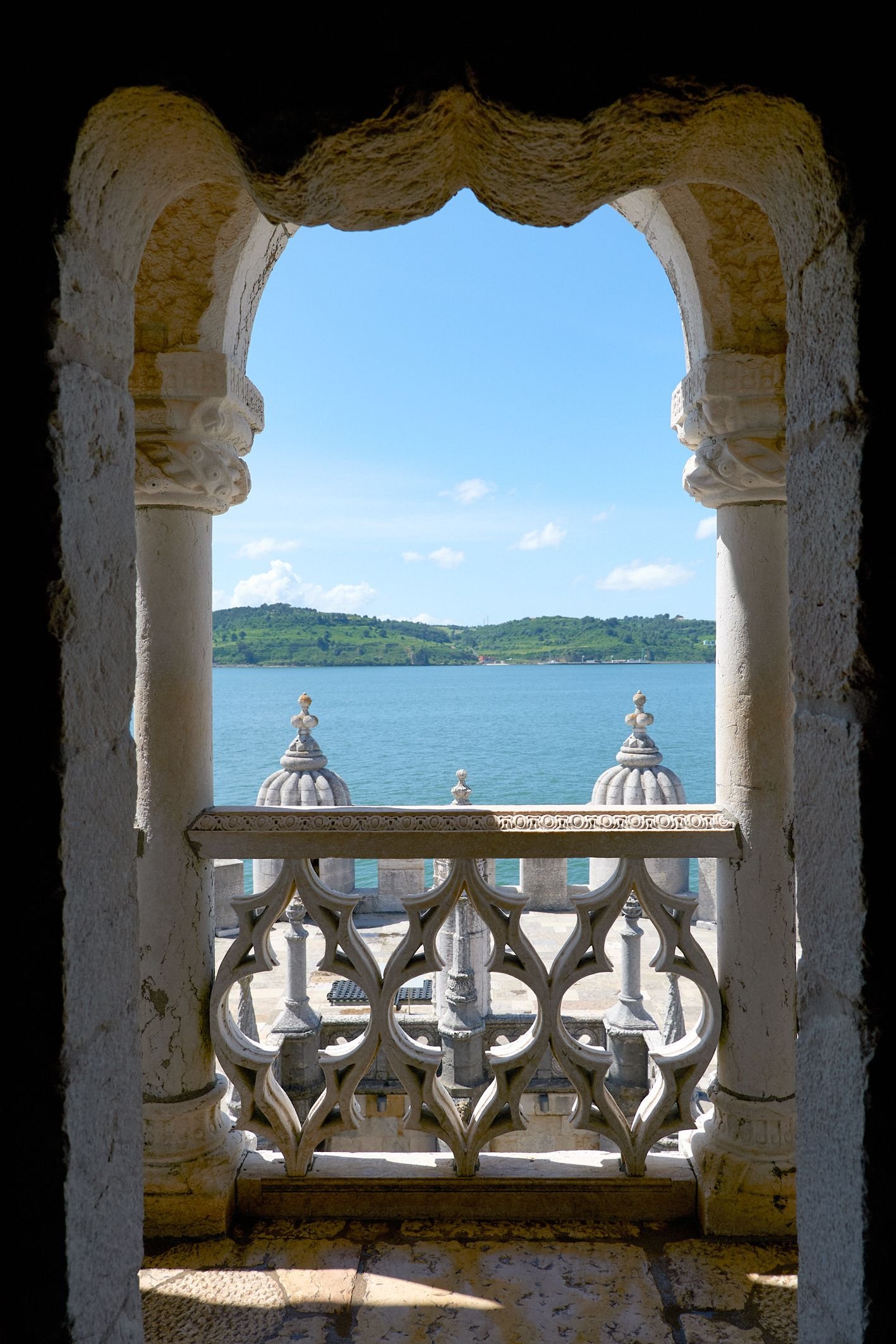The Tagus River framed by a carved window at Belém Tower.