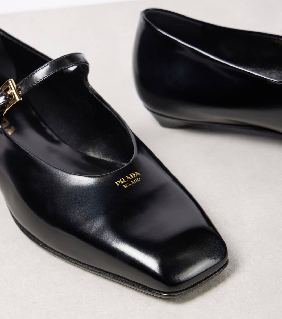 Close-up of square-toe black leather Mary Jane flats.