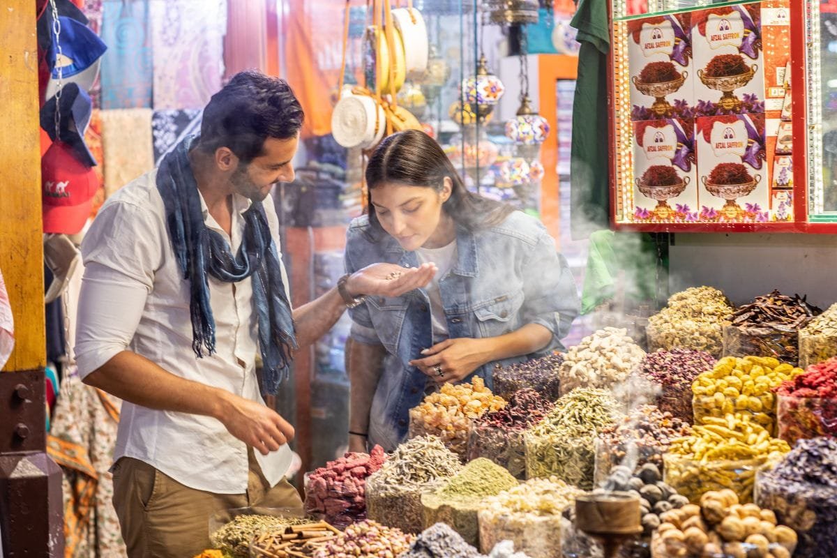 Visitors browsing spices with a merchant in Dubai’s Spice Souk