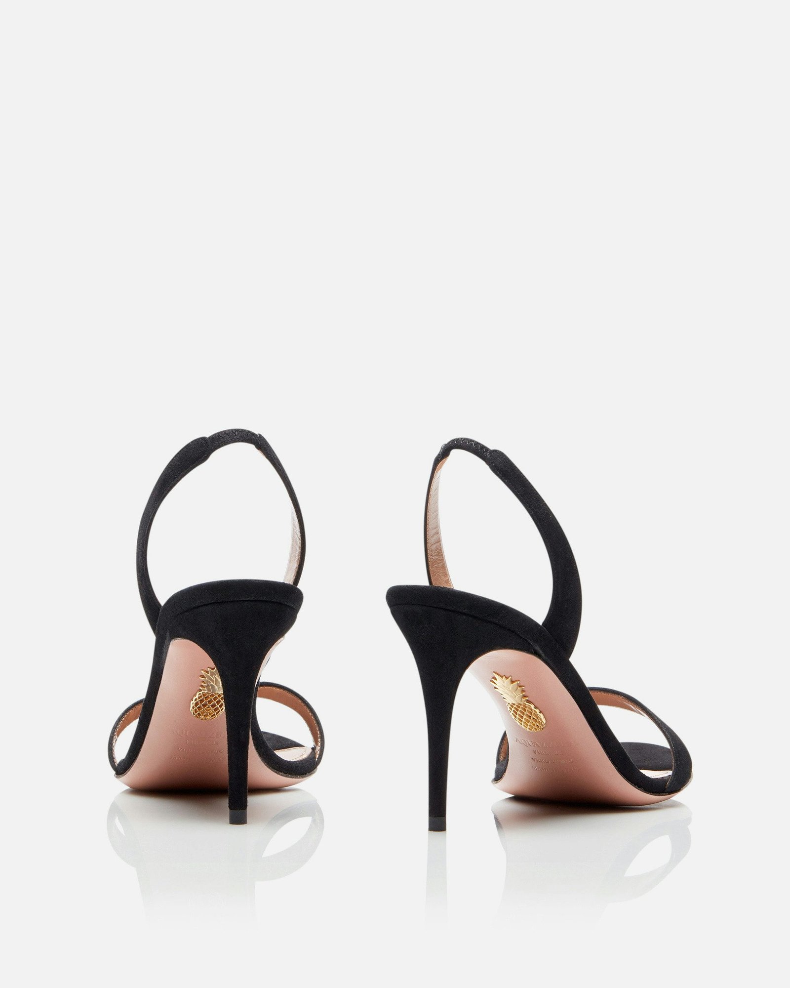 Rear view of black suede Aquazzura So Nude sandals and their slender heels.