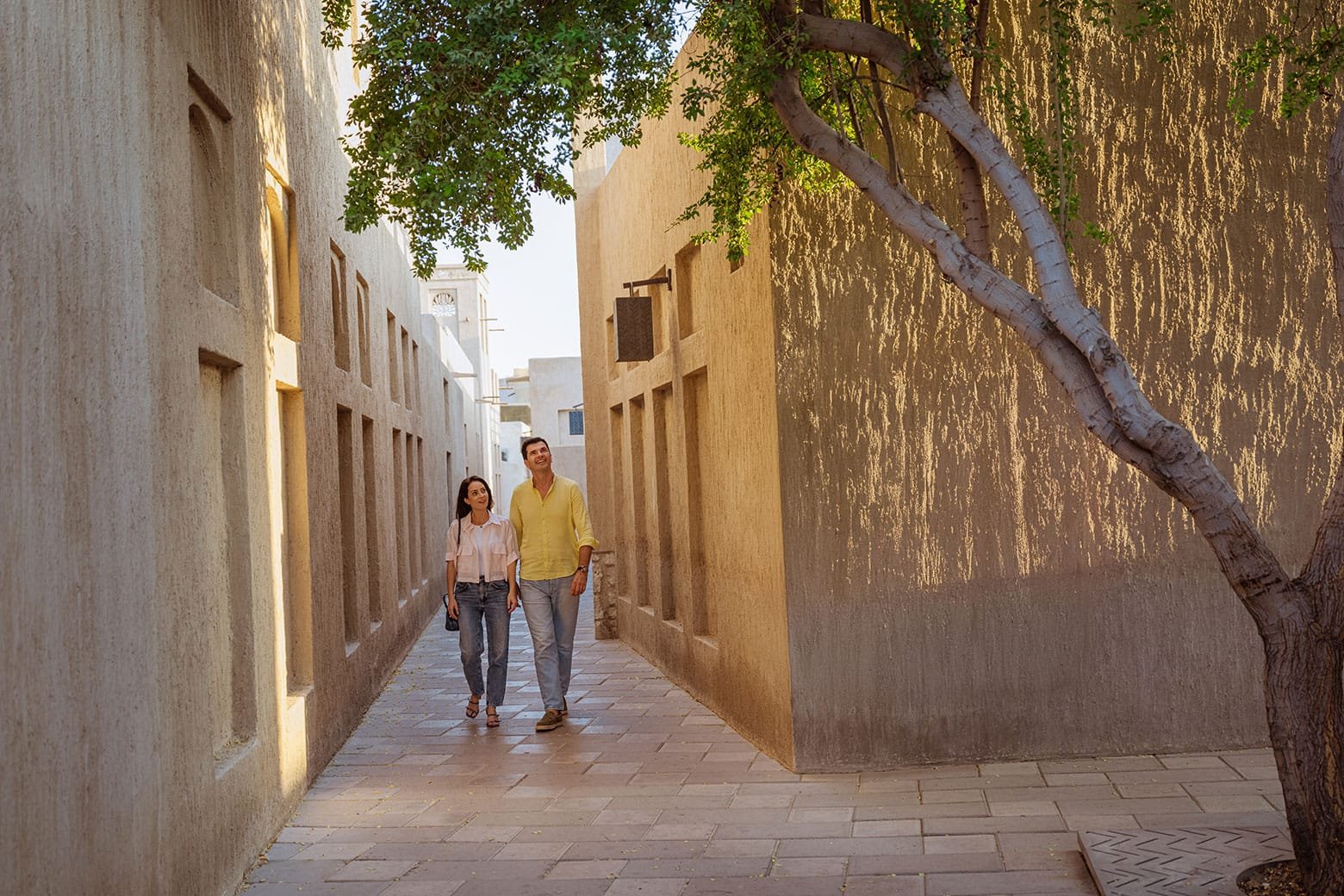 Visitors walking along a shaded Al Fahidi lane