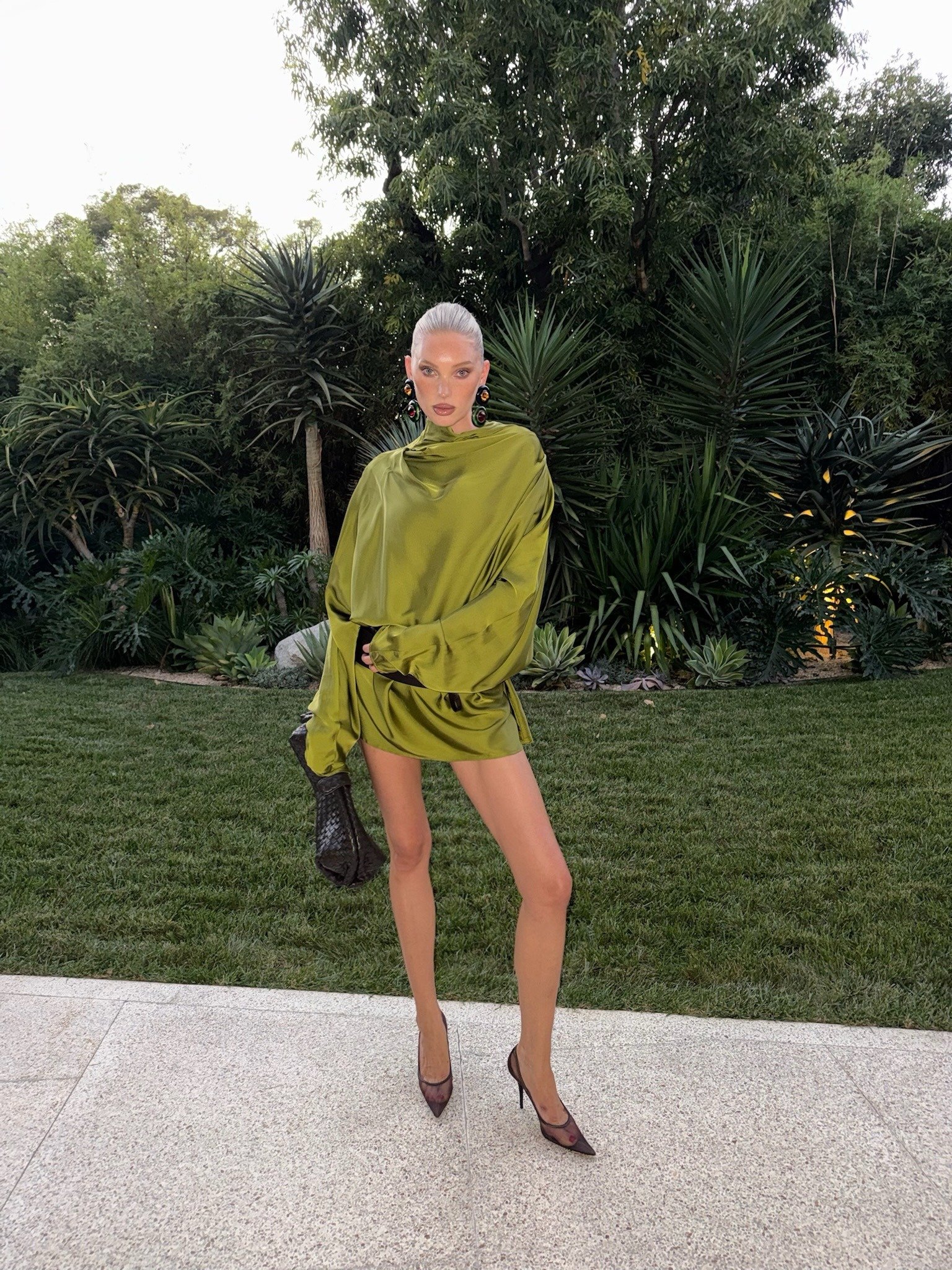 Black mesh heels styled with a simple green dress