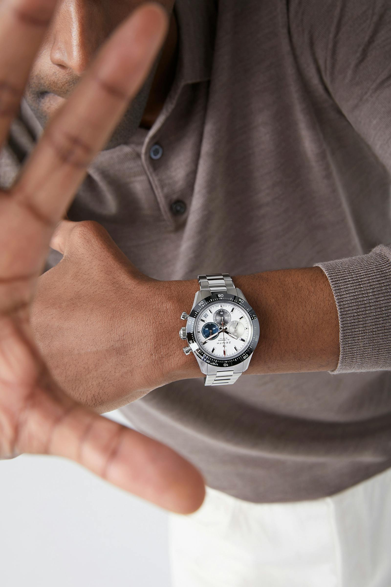 Model wearing a Zenith Chronomaster Sport with light casual clothing.