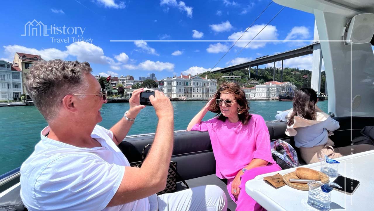 Seated guests photographing the view from a Bosphorus yacht.
